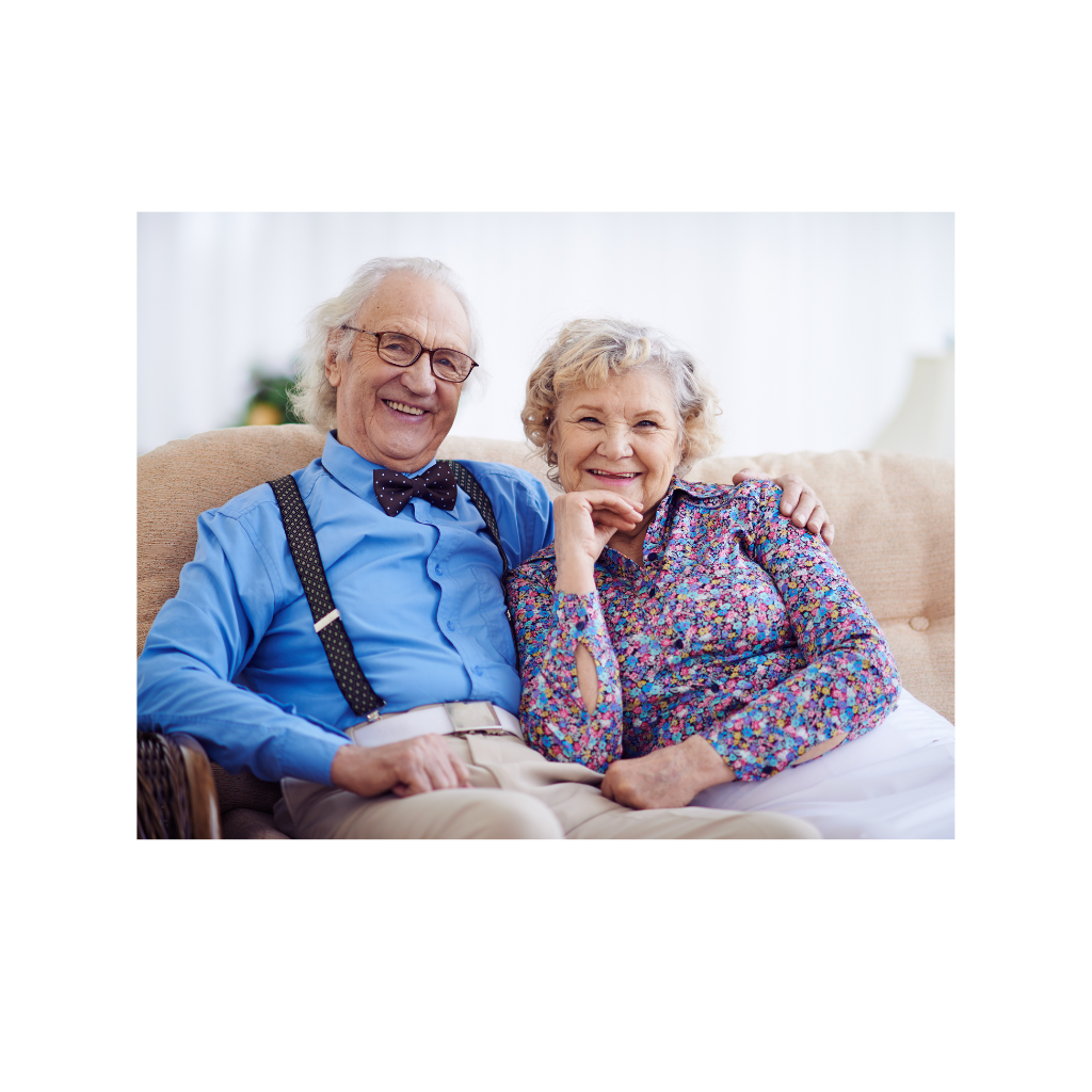Couple agé souriants sur divan.png